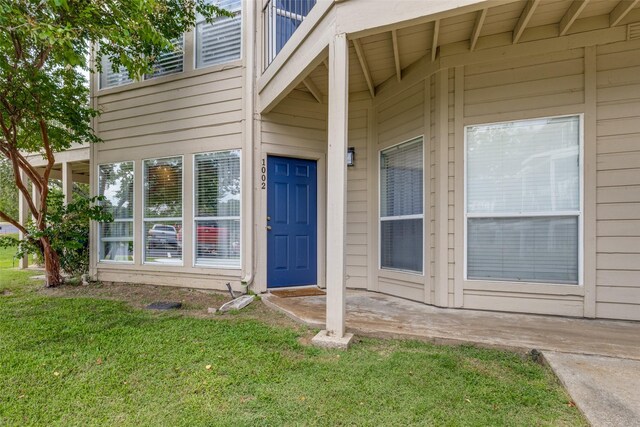 view of exterior entry with a lawn