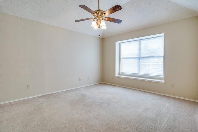 carpeted spare room featuring a textured ceiling and ceiling fan