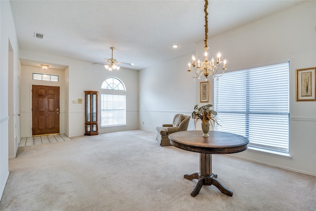 interior space with ceiling fan with notable chandelier, a textured ceiling, a healthy amount of sunlight, and high vaulted ceiling