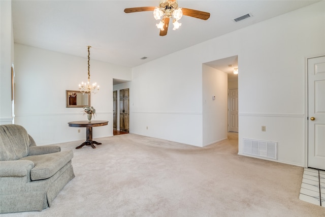 living area featuring ceiling fan with notable chandelier and light carpet