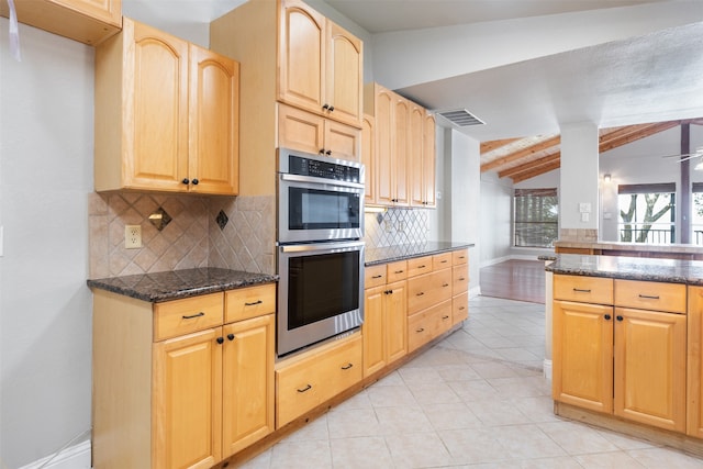 kitchen featuring vaulted ceiling with beams, double oven, and light tile patterned floors