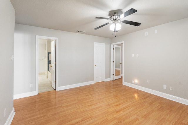 unfurnished bedroom featuring ceiling fan, light wood-type flooring, and ensuite bath