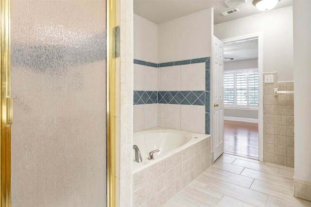 bathroom featuring shower with separate bathtub and tile patterned flooring