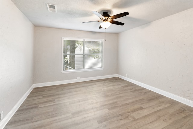 spare room with ceiling fan, a textured ceiling, and hardwood / wood-style flooring