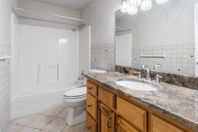 full bathroom with tile patterned floors, vanity, tile walls, and toilet