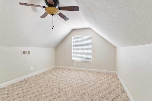 bonus room with ceiling fan, a textured ceiling, carpet, and lofted ceiling