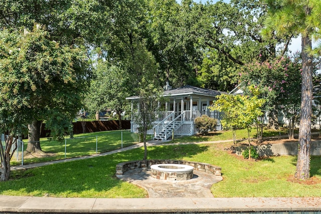 view of community with a lawn and a fire pit