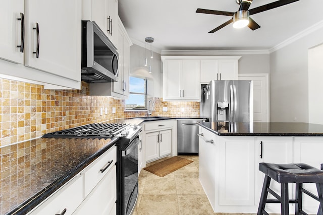 kitchen with appliances with stainless steel finishes, white cabinetry, crown molding, decorative light fixtures, and sink