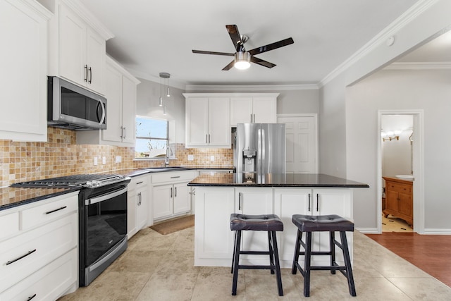 kitchen featuring crown molding, light hardwood / wood-style floors, a center island, and stainless steel appliances