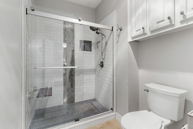 bathroom featuring walk in shower and toilet