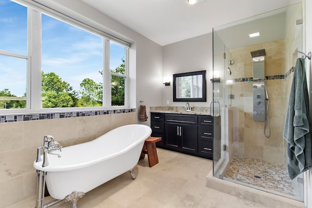 bathroom with tile walls, vanity, and separate shower and tub