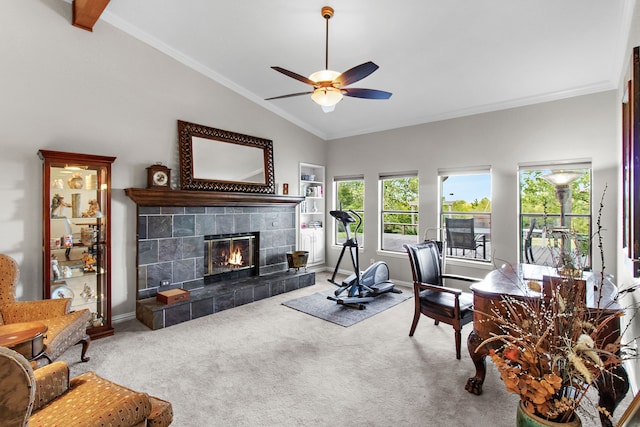 living room featuring vaulted ceiling, ceiling fan, a tile fireplace, and carpet flooring