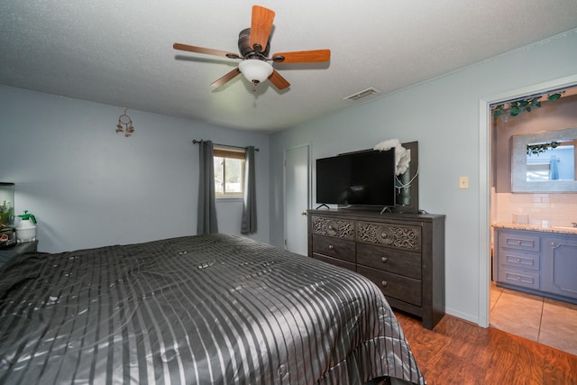 bedroom featuring visible vents, a ceiling fan, and wood finished floors