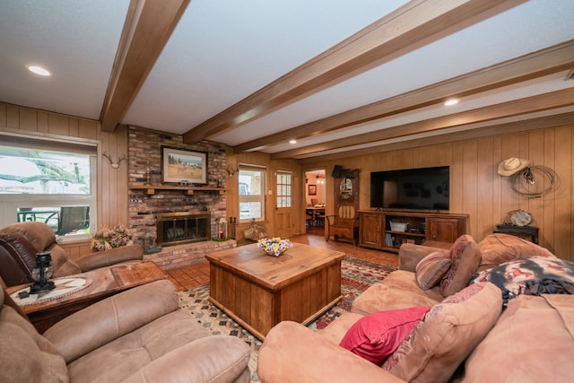 living room with beam ceiling, wooden walls, and a fireplace