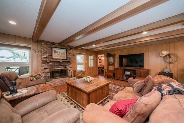 living area with wood walls, a brick fireplace, and a wealth of natural light