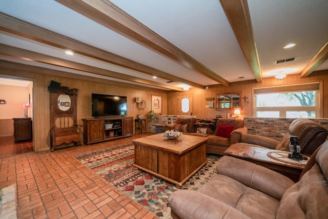 living room featuring visible vents, wood walls, beamed ceiling, recessed lighting, and brick floor