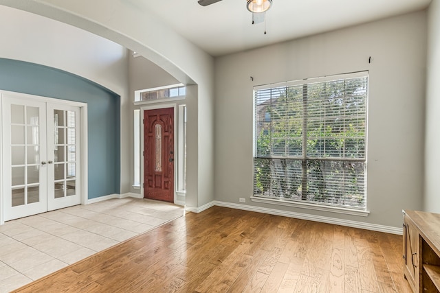 foyer with ceiling fan, french doors, light wood-type flooring, and baseboards