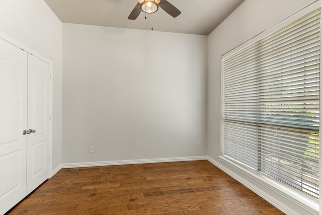 spare room featuring a wealth of natural light, baseboards, wood finished floors, and a ceiling fan