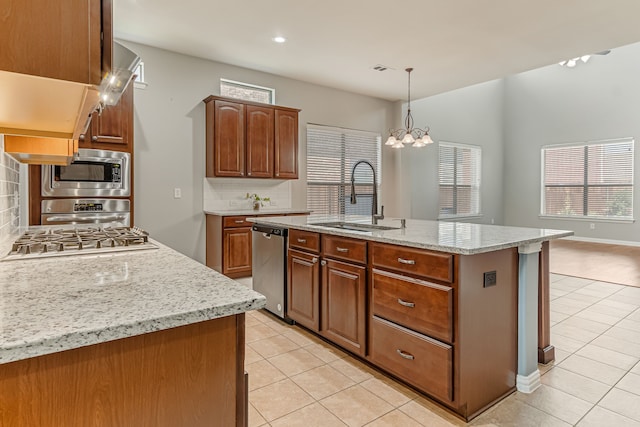 kitchen with decorative light fixtures, light tile patterned floors, decorative backsplash, stainless steel appliances, and a sink