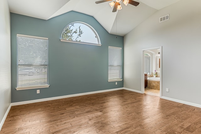 unfurnished bedroom with visible vents, lofted ceiling, baseboards, and wood finished floors