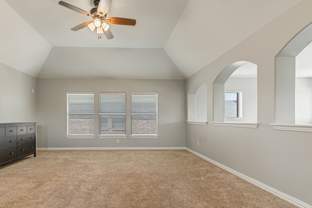 interior space with baseboards, lofted ceiling, light colored carpet, and ceiling fan