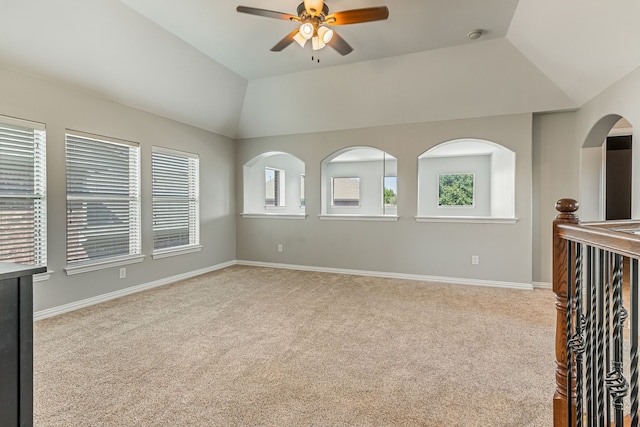 spare room with a healthy amount of sunlight, baseboards, carpet, and lofted ceiling