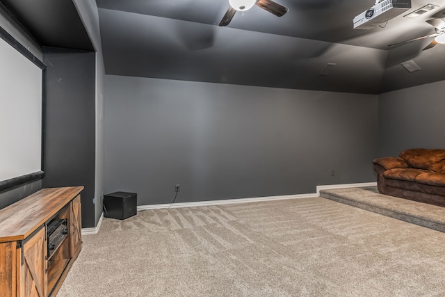 home theater featuring carpet flooring, baseboards, ceiling fan, and vaulted ceiling