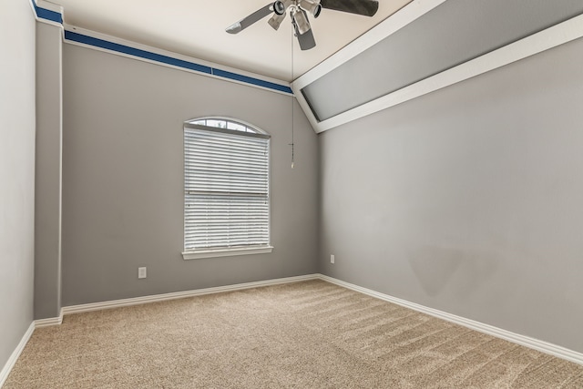 carpeted empty room featuring vaulted ceiling, baseboards, and ceiling fan