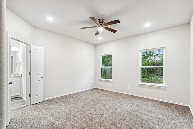 unfurnished room with light colored carpet and ceiling fan