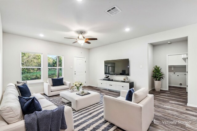 living room featuring ceiling fan and dark wood-type flooring