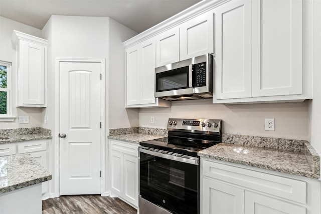 kitchen featuring light stone counters, dark hardwood / wood-style flooring, white cabinetry, and stainless steel appliances