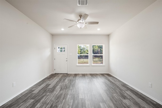 interior space with baseboards, visible vents, dark wood finished floors, and a ceiling fan