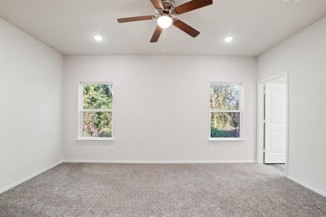 carpeted empty room featuring a wealth of natural light, baseboards, and recessed lighting