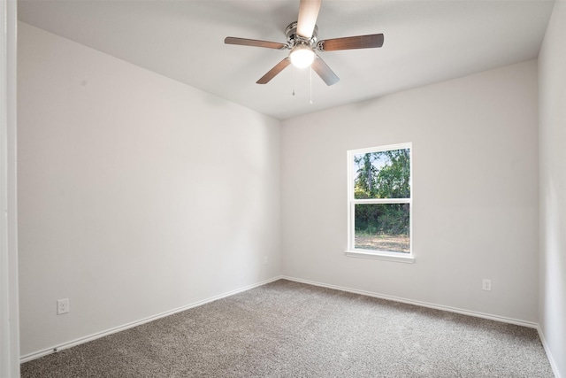 carpeted empty room with ceiling fan and baseboards