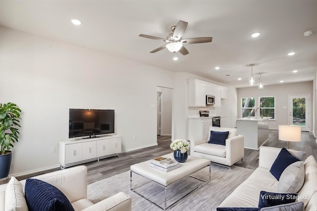 living room with baseboards, ceiling fan, recessed lighting, and light wood-style floors