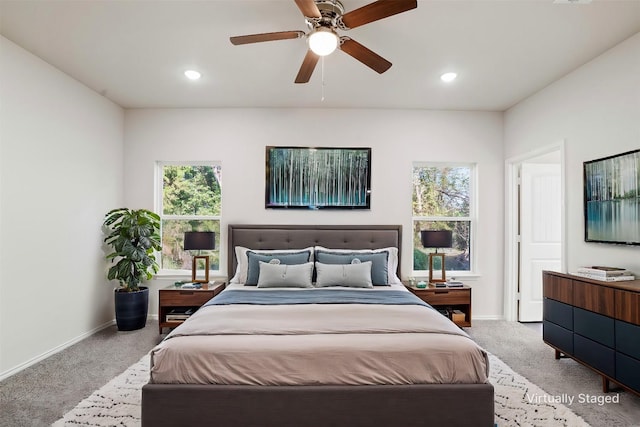 bedroom with light colored carpet, baseboards, and multiple windows