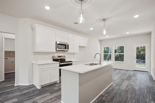 kitchen with decorative light fixtures, light countertops, appliances with stainless steel finishes, white cabinetry, and a sink