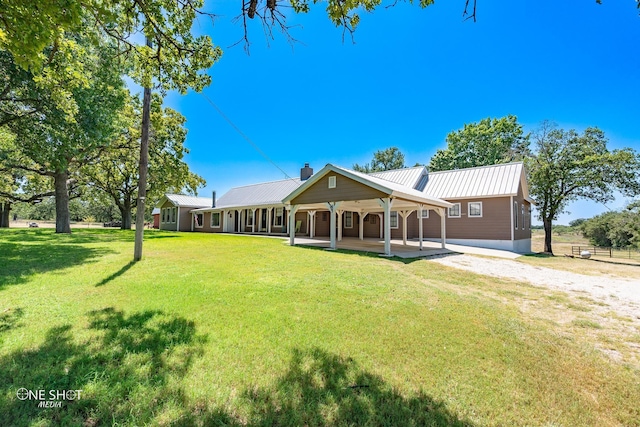 rear view of house with covered porch and a lawn