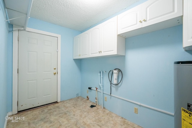 clothes washing area with cabinets, washer hookup, a textured ceiling, and water heater