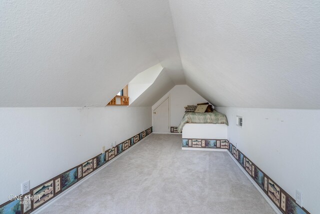 bonus room with light carpet, lofted ceiling, and a textured ceiling