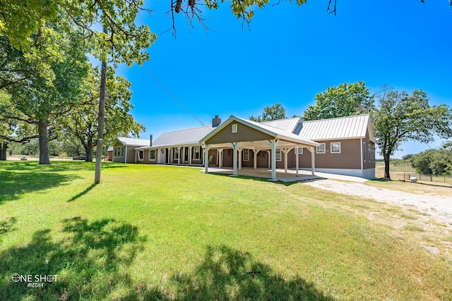 rear view of property with a lawn