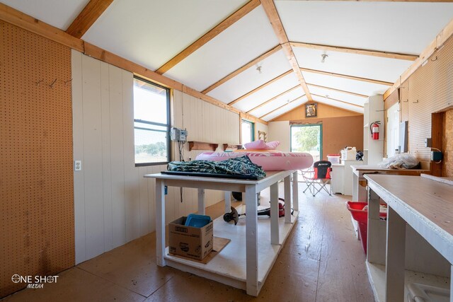 kitchen with lofted ceiling with beams and wood walls