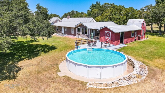 view of swimming pool with an outdoor structure and a lawn