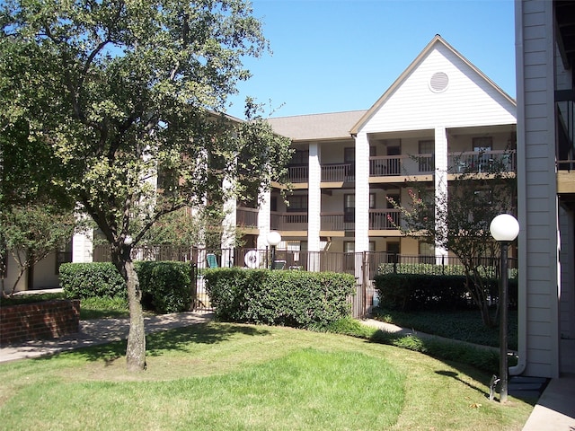 view of front of home featuring a front yard and a balcony