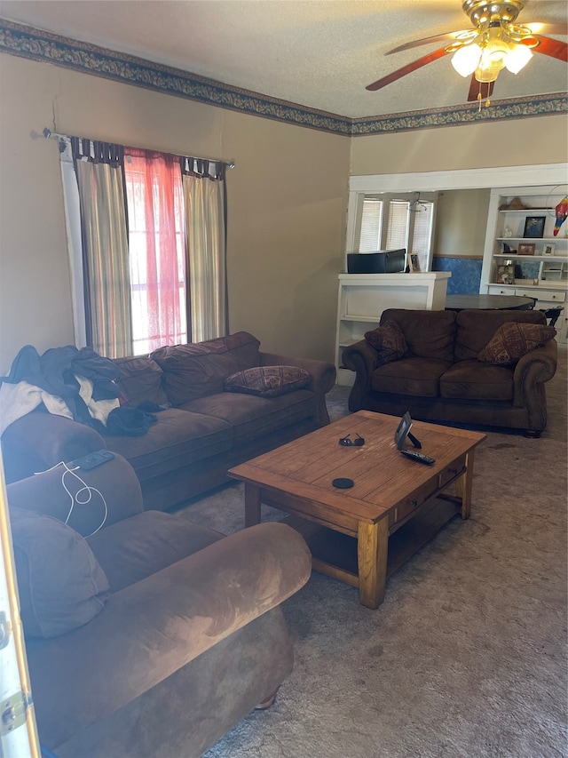 carpeted living room with ceiling fan and a textured ceiling