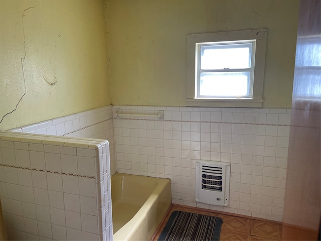 bathroom with tile walls, a washtub, and parquet floors