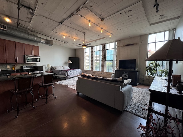 living room with ceiling fan, track lighting, and a wealth of natural light