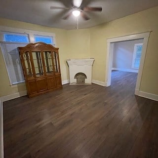 unfurnished living room with dark hardwood / wood-style floors and ceiling fan