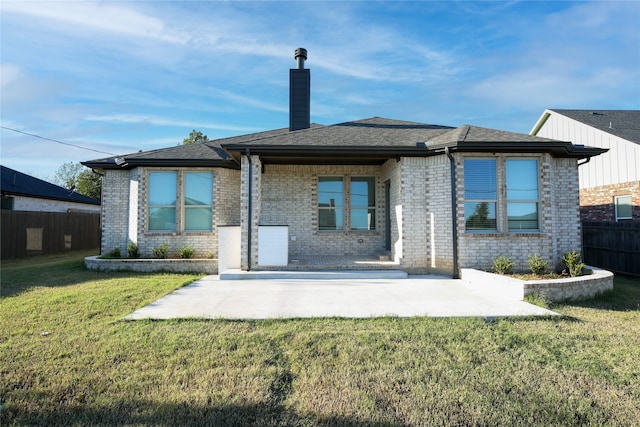 rear view of property with a yard and a patio area