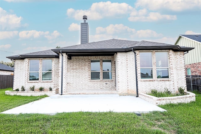 back of property with a yard and a patio area